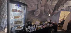 a table with plates of food in a glass case at MILITARY Guest Inn in Drawsko Pomorskie