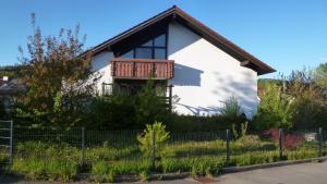 a white house with a balcony on it at Ferienhaus Unteres Hart in Gomadingen
