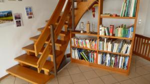 a book shelf full of books next to a staircase at Ferienhaus Unteres Hart in Gomadingen +11 photos