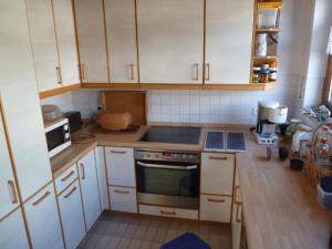 a kitchen with white cabinets and a stove top oven at Ferienhaus Unteres Hart in Gomadingen