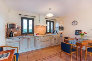 カステルノー・ラ・シャペルにあるMaison Hyacintheの白いキャビネットとテーブルと椅子のあるキッチン +15枚の写真