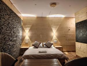 Un dormitorio con una cama y una pared de ladrillo. en The clifftonn stays, en Jibhi