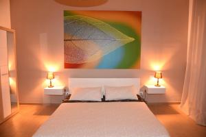 a bedroom with a bed with two lamps and a painting at B&B La Perla & Suites in Bari