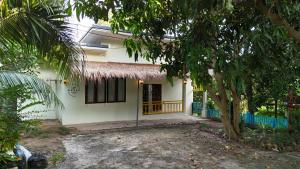 una casa blanca con un árbol delante en The Green Horizon Villa Chaweng Hill, en Koh Samui 