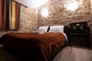 a bedroom with a bed in a stone wall at Rohami in Kalentzi