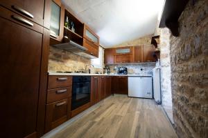 a kitchen with wooden cabinets and a white refrigerator at Rohami in Kalentzi