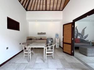 ein Esszimmer mit Tisch und Stühlen und einer Couch in der Unterkunft Zoe Villa Canggu Bali in Canggu