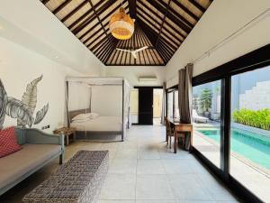 a living room with a bed and a pool at Zoe Villa Canggu Bali in Canggu