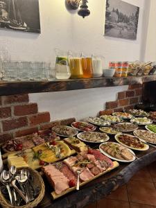 a buffet with many plates of food on a table at Hotel Kopernik in Frombork +25 photos