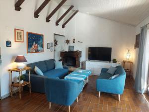 a living room with blue couches and a flat screen tv at Villa with a beautiful sea view near the beach - by Traveler tourist agency Krk ID 2175 in Kornić