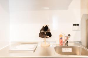 a kitchen counter with a sink with a hat on it at b&黒門1号店 in Osaka