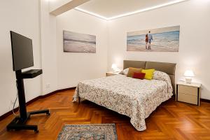 a bedroom with a bed and a flat screen tv at WELCOME RIVIERA -TORRE D'AVORIO APPARTAMENTO 126 mq piu'terrazzo25 mq - totalmente rinnovato- 250 m dal centro - parcheggio a pagamento 20 euro al giorno da prenotare in anticipo salvo dispo -parking at 20 euro per day to be booked in advance if available in Rapallo