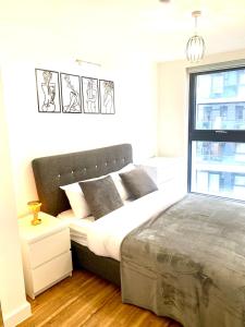 een slaapkamer met een groot bed en een raam bij Lux Stylish 2 Bed High Rise with Parking and Balcony in Manchester