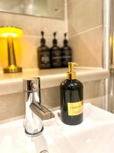 een fles zeep op een wastafel in de badkamer bij Lux Stylish 2 Bed High Rise with Parking and Balcony in Manchester +18 foto's