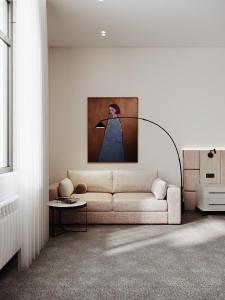 een woonkamer met een bank en een schilderij aan de muur bij Grand Dior in Tasjkent