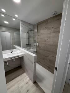 a white bathroom with a shower and a sink at Hotel Radona 