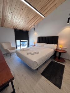 a bedroom with a large white bed with a wooden ceiling at Hotel Radona 