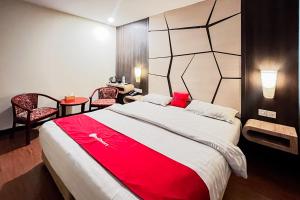 a bedroom with a large bed with a red blanket at RedDoorz Plus at Paragon Nagoya Hotel Batam in Nagoya