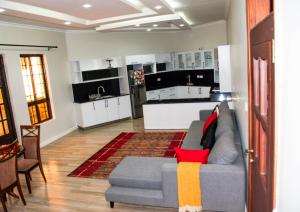 a living room with a couch and a kitchen at Ekom Nest in Musereita