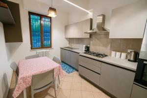 a kitchen with a table with a pink table cloth at WELCOME RIVIERA -TORRE D'AVORIO APPARTAMENTO 126 mq piu'terrazzo25 mq - totalmente rinnovato- 250 m dal centro - parcheggio a pagamento 20 euro al giorno da prenotare in anticipo salvo dispo -parking at 20 euro per day to be booked in advance if available in Rapallo