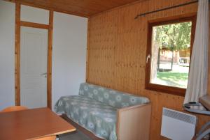 a small room with a couch and a window at Camping du Haut-Koenigsbourg - Onlycamp in Lièpvre