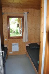 a small room with a bed and a window at Camping du Haut-Koenigsbourg - Onlycamp in Lièpvre