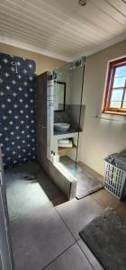 a bathroom with a glass shower with a sink at Die Steenkamps in Sutherland