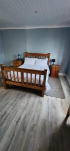 a bedroom with a large bed and wooden floors at Die Steenkamps in Sutherland