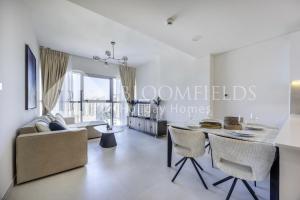 MushayribにあるBloomfields Iconic 2 Br Radiant Boulevard Reemのテーブルとソファのあるリビングルーム