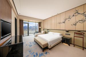 une chambre avec deux lits et une télévision à écran plat dans l'établissement Chongqing Ronghui Grand Hotel, à Chongqing