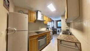 a small kitchen with a refrigerator and a sink at Mirador de Sanvi - tucasaenlospirineos in Sallent de Gállego