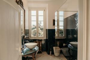 a bathroom with two sinks and two mirrors at Castello di Pasturana in Pasturana
