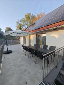 a patio with a table and chairs under an umbrella at Dióliget Apartman in Orfű +12 photos