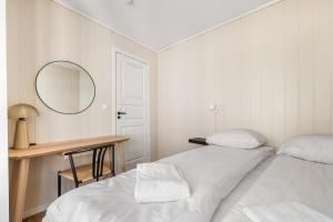 ein weißes Schlafzimmer mit zwei Betten und einem Spiegel in der Unterkunft Charming Townhouse - Walk Everywhere! in Bergen