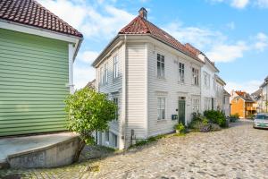 ein altes weißes Haus mit einem Türmchen neben einer Straße in der Unterkunft Charming Townhouse - Walk Everywhere! in Bergen