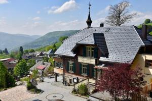an old house with a steep roof in a village at Hotel & Chalets Herrihof in Todtnauberg