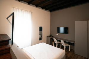 a bedroom with a bed and a desk with chairs at Cà del Borgo in Vizzola Ticino