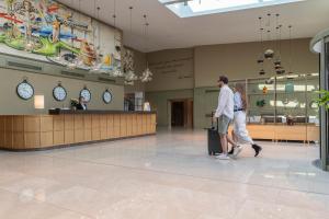 a man and woman walking through a shopping mall at Saint Sofia Golf Club, Hotel and SPA in Robertowo