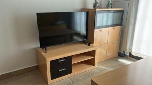 a flat screen tv sitting on a wooden entertainment center at Apartamento Camarena de La Sierra in Camarena de la Sierra