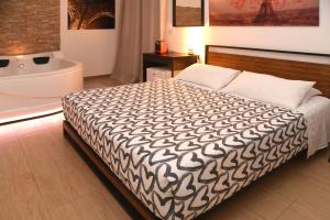 a bedroom with a bed with a black and white blanket at B&B La Perla & Suites in Bari