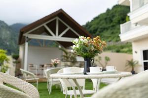 ein Tisch mit einer Vase mit Blumen darauf in der Unterkunft The Village Luxury Stay in Jāmb