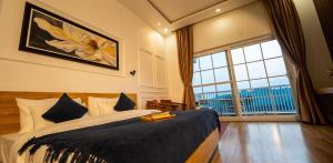 ein Schlafzimmer mit einem großen Bett und einem großen Fenster in der Unterkunft The Village Luxury Stay in Jāmb