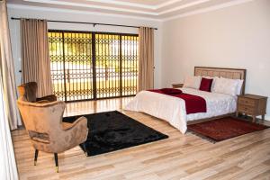 a bedroom with a bed and a chair and a window at Ekom Nest in Musereita