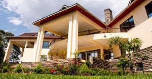 a house with a porch and a balcony at Ekom Nest in Musereita +13 photos