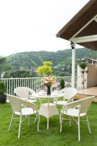 eine Gruppe von Stühlen und ein Tisch auf einer Terrasse in der Unterkunft The Village Luxury Stay in Jāmb + 2 Fotos
