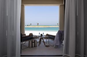 a dining room with a view of the beach at Jumeirah Gulf of Bahrain in Manama