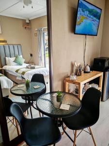 ein Zimmer mit 2 Tischen und Stühlen und ein Schlafzimmer in der Unterkunft The Lion's Den in George
