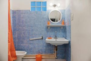 a blue tiled bathroom with a sink and a mirror at Appartement 2eme étage in Castellane +12 photos