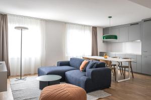 a living room with a blue couch and a table at PopUp - Stay3 self check in Apartments in Zürich