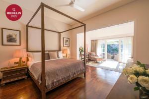 Un dormitorio con cama con dosel y una sala de estar. en W15 Hanthana Estate Kandy, en Kandy